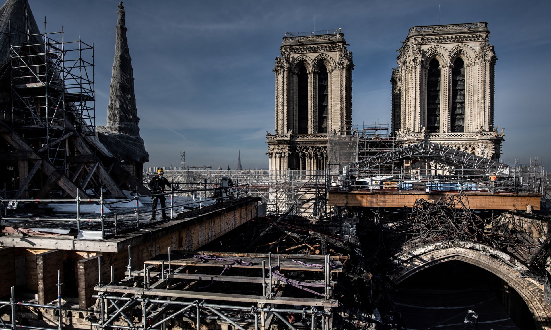 Workers on the roof of Notre Dame removing the burnt scaffolding that surrounded the spire